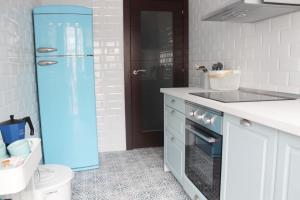a kitchen with a blue refrigerator next to a sink at Jovellanos Playa in Ribadesella
