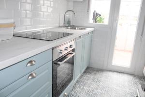 a white kitchen with a sink and a counter at Jovellanos Playa in Ribadesella