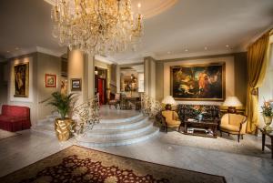 a lobby with a staircase and a chandelier at Hotel Bristol Salzburg in Salzburg