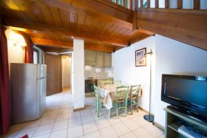 una cucina e una sala da pranzo con tavolo e TV di Residence Villa Frejus a Bardonecchia