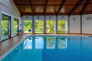 an indoor swimming pool with blue water in a house at Warren House Hotel in Kingston upon Thames