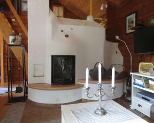 uma sala de estar com lareira e uma mesa com velas em Ferienhaus Eulennest em Hilders