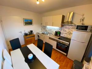 a kitchen with a table and a white refrigerator at Ferienwohnung Augsburg 1 in Augsburg