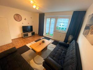 ein Wohnzimmer mit einem Sofa und einem Tisch in der Unterkunft Ferienwohnung Augsburg 1 in Augsburg