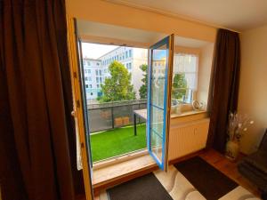 een kamer met een deur naar een balkon met een raam bij Ferienwohnung Augsburg 1 in Augsburg