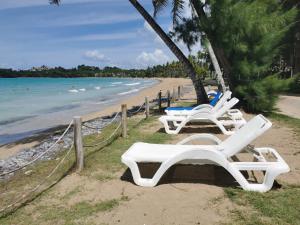 2 sillones blancos sentados en una playa en Casa Grande Hotel Restaurant, en Las Terrenas