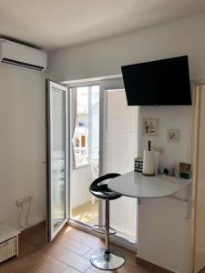 - une cuisine avec une table et un tabouret dans une pièce dans l'établissement Apartment Kristina, à Novalja