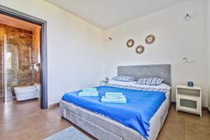 1 dormitorio con 1 cama extragrande con sábanas azules en Villa ELEA, en Novi Vinodolski