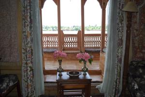 a room with two vases with flowers on a table at Jackson Heights Houseboats in Srinagar