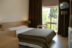 a hotel room with a bed and a window at Arcada Hotel in Tocha +12 photos