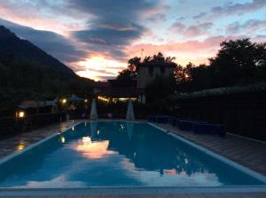 a large swimming pool with a sunset in the background at Locanda del Ponte B&B in Balsorano Vecchio