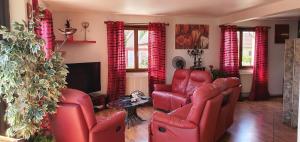 a living room with red leather chairs and a television at Maison de vacances proche Strasbourg et Europa park in Sand