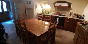 a kitchen with a wooden table with chairs and a sink at Legacy Scanno in Scanno
