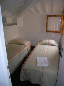 a small room with two beds and a window at Villa Violetta in Castiglioncello