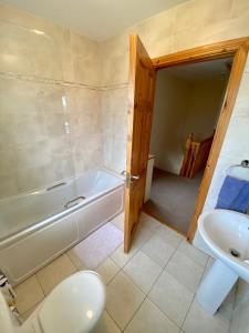 uma casa de banho com uma banheira, um WC e um lavatório. em Castlebaldwin Country Residence em Sligo