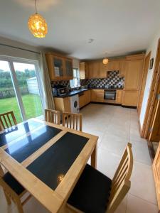 a kitchen and dining room with a wooden table and chairs at Castlebaldwin Country Residence in Sligo