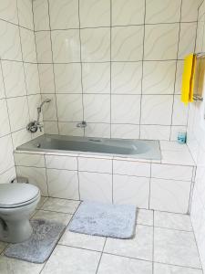 a bathroom with a tub and a toilet at The Home in Richards Bay