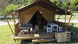 a gazebo with chairs and a table in a field at le Moulin de Cost in Buis-les-Baronnies