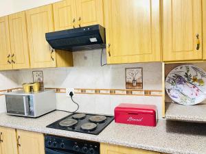 a kitchen with a stove and a microwave at The Home in Richards Bay