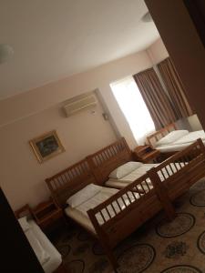 a room with two beds and a window at Pensiunea Sydney in Timişoara
