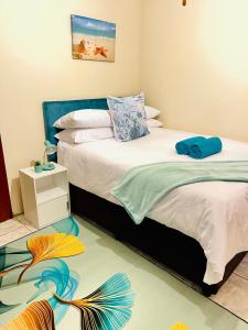 1 dormitorio con 2 camas y un cuadro en la pared en The Home en Richards Bay