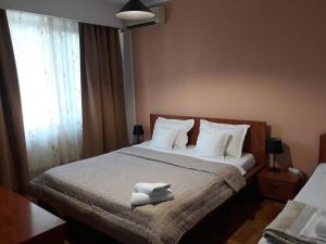 a bedroom with a bed with towels on it at Pensiunea Sydney in Timişoara