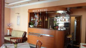 a bar in a restaurant with a table and chairs at Hotel Isabell Győr in Győr