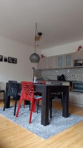 una cocina con mesa negra y sillas rojas en Harrachovský apartmán, en Harrachov