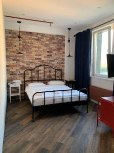 a bedroom with a bed in front of a brick wall at Art Hotel in Pykhtino