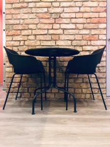una mesa negra y dos sillas frente a una pared de ladrillo en Flamingo apartment (FA), en Riga 9 fotos más
