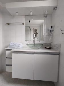 a bathroom with a sink and white cabinets at Rua Dr. Diogo de Faria, 671 apto 22 in Sao Paulo