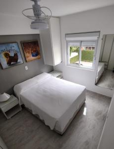 a bedroom with a large white bed and a window at Rua Dr. Diogo de Faria, 671 apto 22 in Sao Paulo