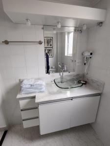 a white bathroom with a sink and a mirror at Rua Dr. Diogo de Faria, 671 apto 22 in Sao Paulo