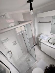 a white bathroom with a shower and a sink at Rua Dr. Diogo de Faria, 671 apto 22 in Sao Paulo