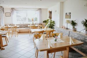 a restaurant with wooden tables and chairs and a window at Landgasthof Hotel Will in Neuenstein