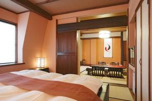 1 dormitorio con 1 cama grande y espejo en Sawaemon, en Chino