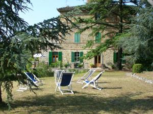 a group of lawn chairs in front of a house at Villa Il Torrino in Monteleone dʼOrvieto