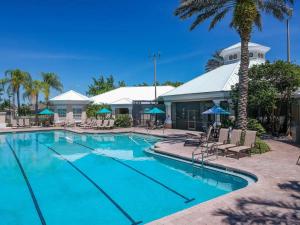 una piscina con sillas y sombrillas en un complejo en 3 Bedroom Resort Style Condo, 3 Miles to Disney!, en Kissimmee