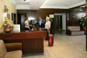 a group of people standing at a reception desk in a lobby at Arcada Hotel in Tocha