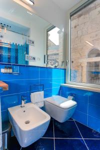 a blue bathroom with a sink and a toilet at La Suite Del Cavaliere in Amalfi