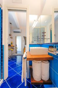 een blauwe badkamer met een wastafel en een spiegel bij La Suite Del Cavaliere in Amalfi