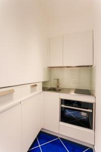 a kitchen with white cabinets and a stove top oven at La Suite Del Cavaliere in Amalfi