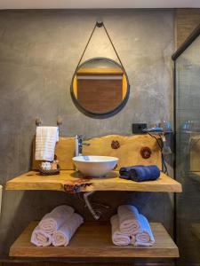 a bathroom with a sink and a mirror and towels at DOM Hotel in Campos do Jordão +34 photos