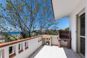 a balcony with a chair and a view of the ocean at La terrazza di S'Oru 'e Mari in Quartu SantʼElena