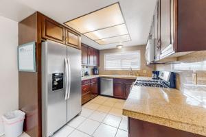 a kitchen with a stainless steel refrigerator and wooden cabinets at Indio Desert Diamond Permit# 50842 in Indio