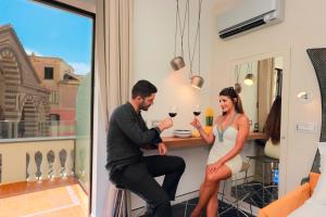 a man and a woman sitting at a counter drinking wine at La Suite Del Cavaliere in Amalfi