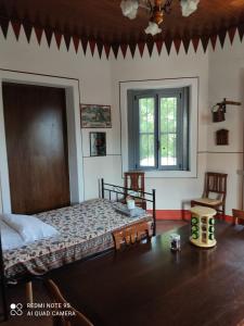 a bedroom with a bed and two chairs and a window at Agriturismo Villa Brugolta in Lavena Ponte Tresa