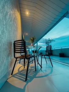 two chairs and a table on a balcony with the ocean at White Orchid in Cox's Bazar