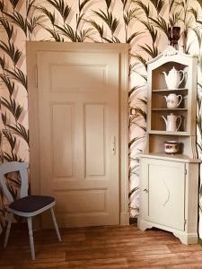 a room with a door and a chair and a shelf at Haus Claudia in Schneverdingen