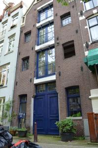 a large brick building with a blue door at Rembrandtplein Bed & Breakfast in Amsterdam